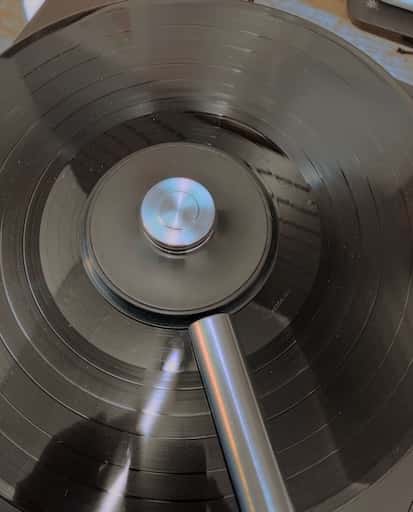Close-up of a vinyl record being cleaned with professional-grade equipment